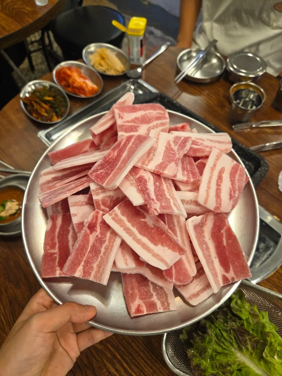 Three servings of frozen pork belly on the stone grill plate