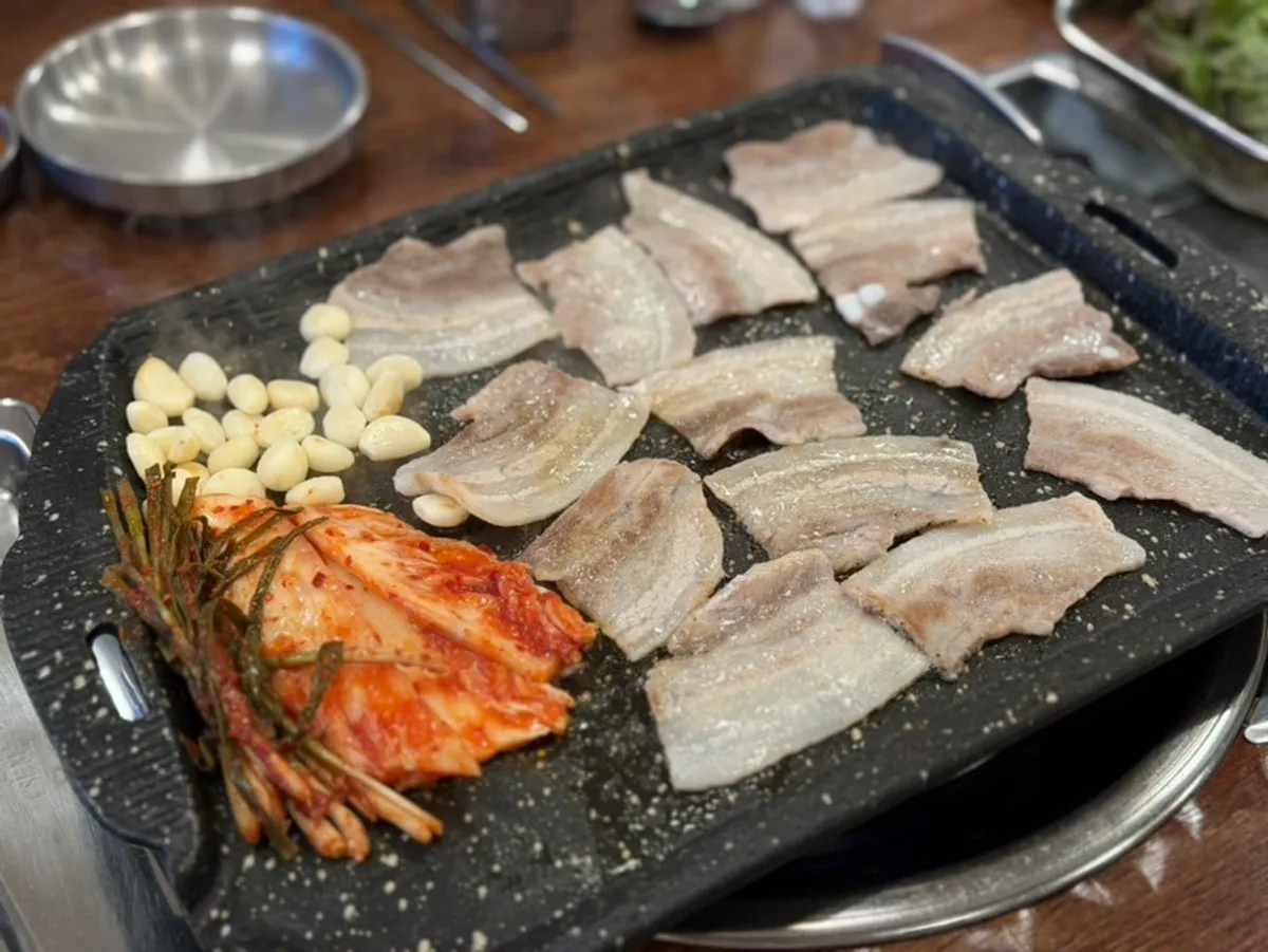 불판에서 노릇하게 구워지는 냉동삼겹살