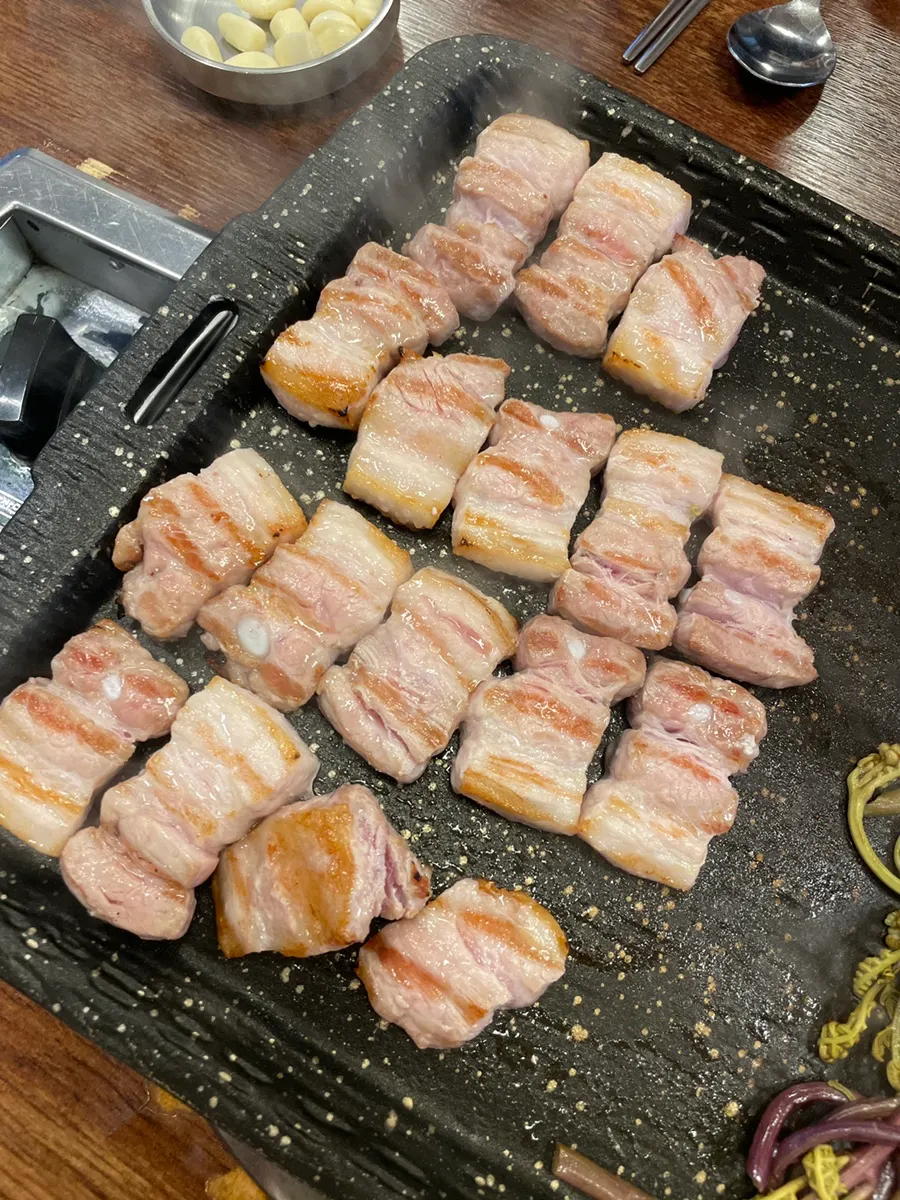 불판 위 통삼겹살과 고사리