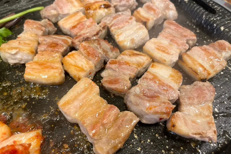Grilled frozen pork belly on the barbecue plate