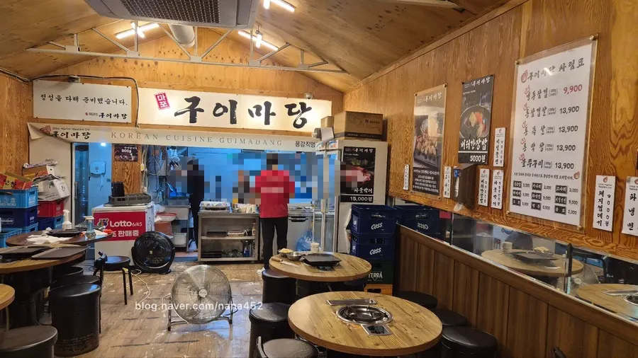 원형 스텐 테이블이 놓인 고깃집 내부