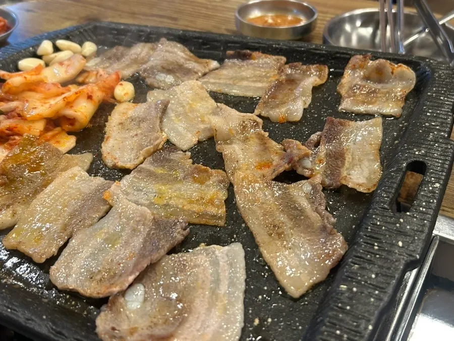 Eating bibim-myeon topped with pork belly