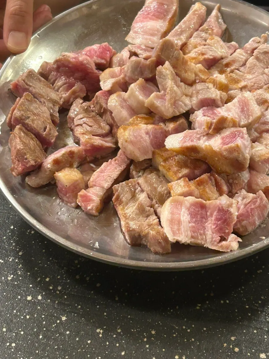 Table spread of charcoal pre-grilled raw pork belly and pork neck
