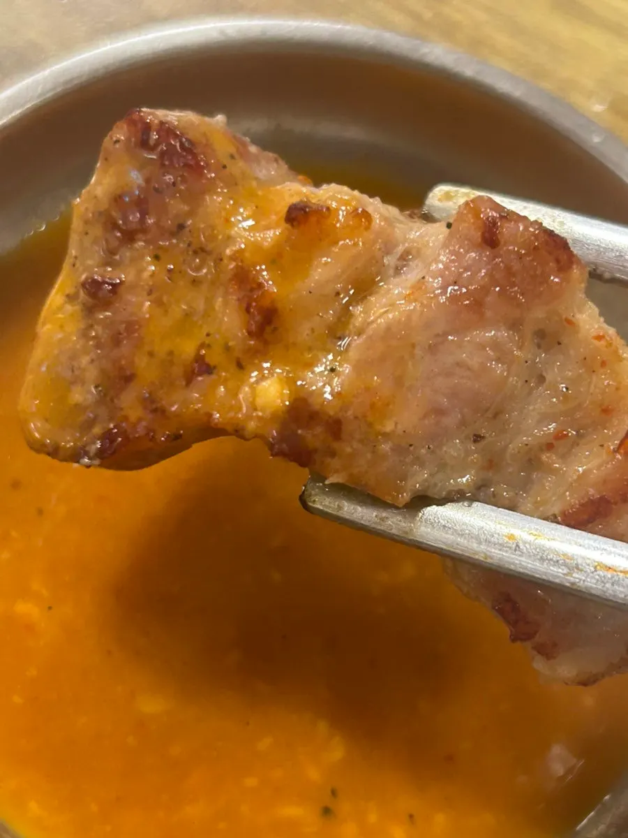 A piece of meat served with the sauce