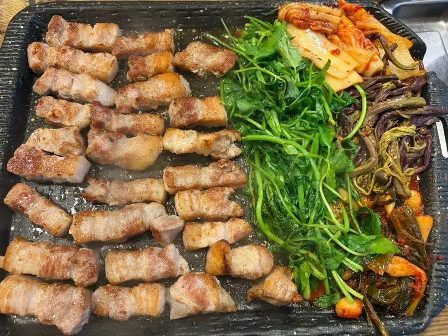 불판 위에서 노릇하게 구워지는 생통삼겹살