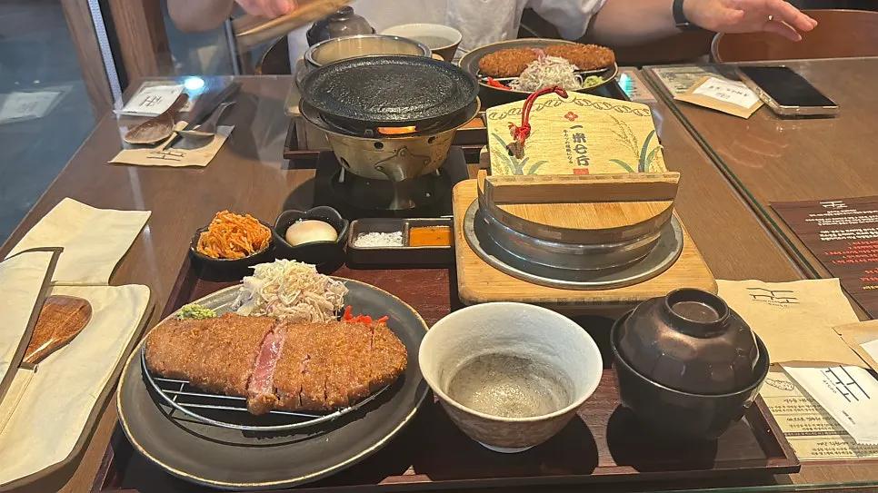 Full spread with gyukatsu, broth soup, side dishes, and pot rice