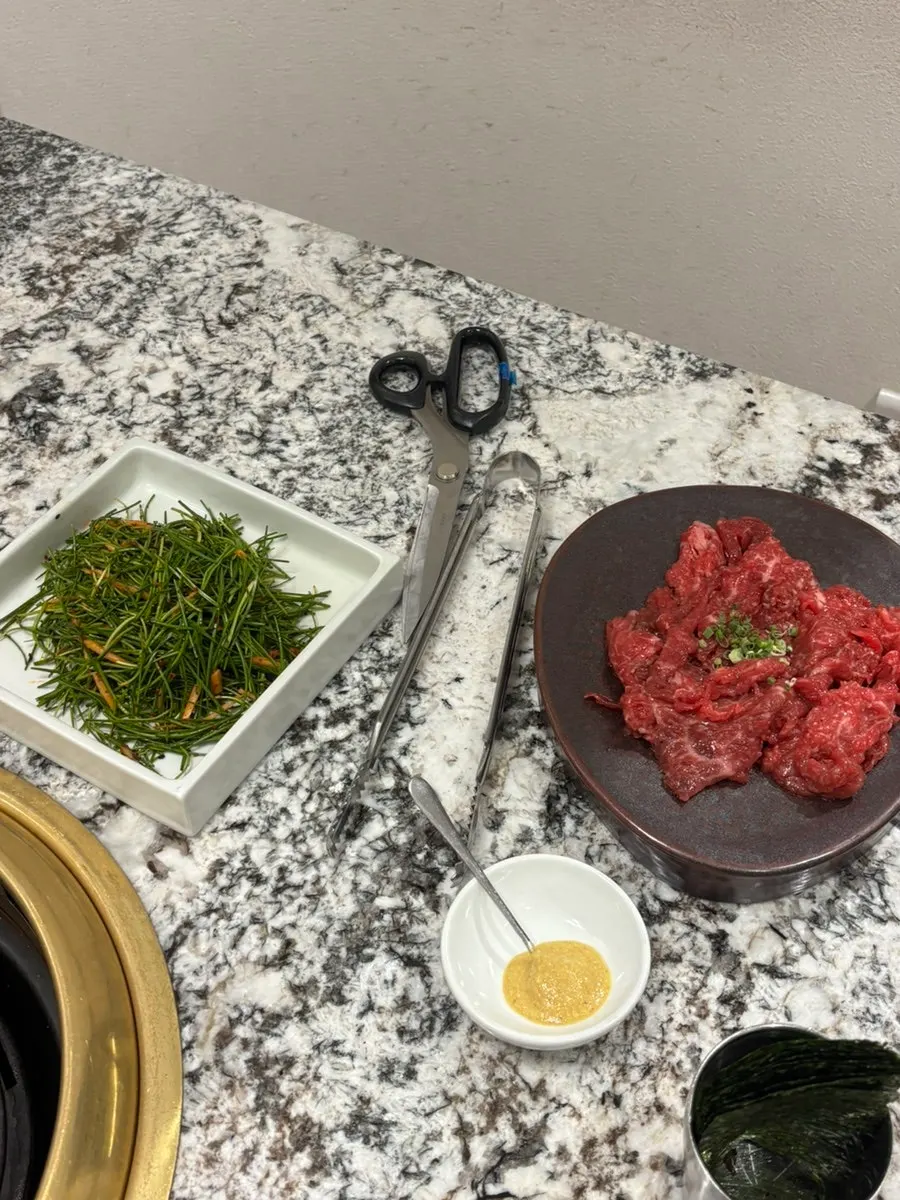 Seasoned hanwoo cooking over charcoal