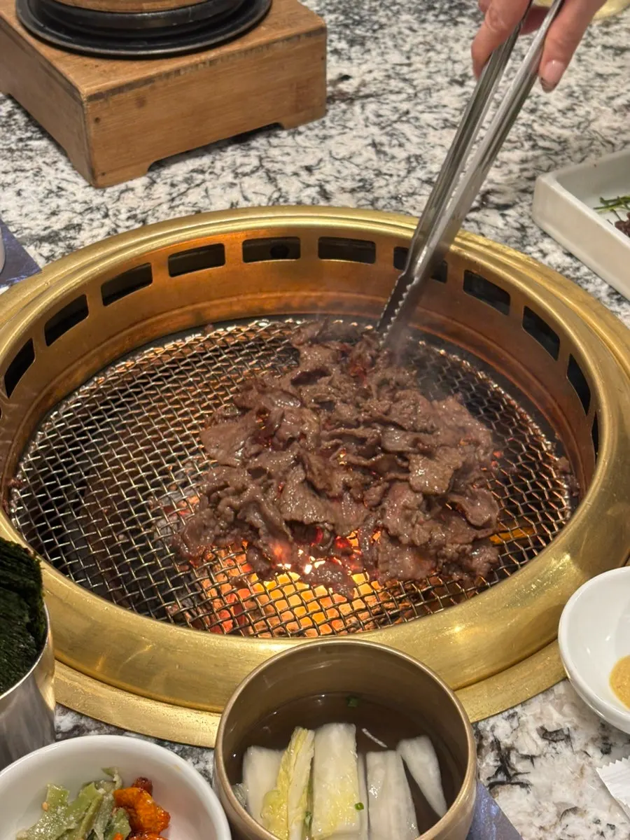 Staff member grilling the charcoal-grilled seasoned hanwoo