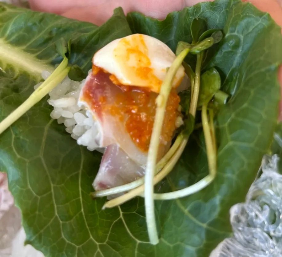 A piece of sashimi dipped in wasabi soy sauce