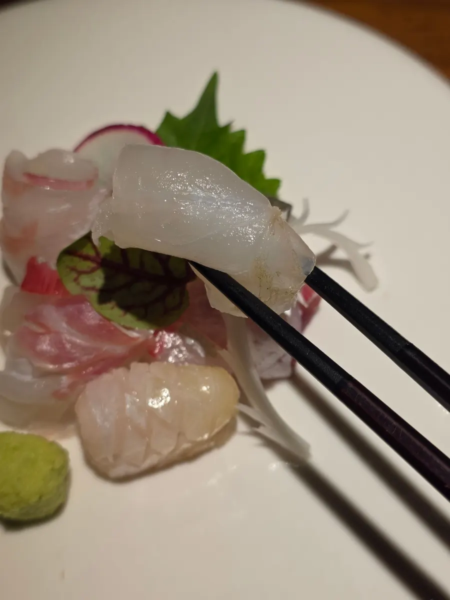 Plate of seven sashimi pieces including flounder, amberjack and mullet