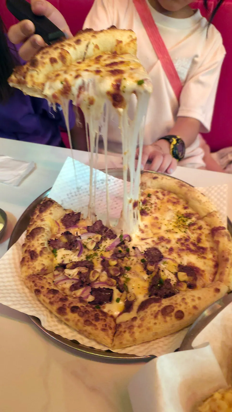 A slice of double cheese pizza with stretchy cheese