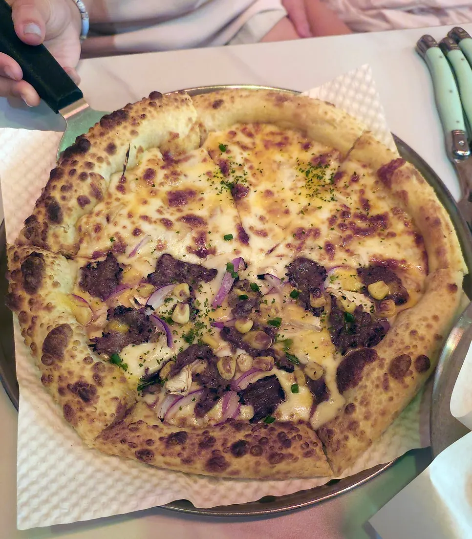 Close-up of a pizza slice loaded with bulgogi topping