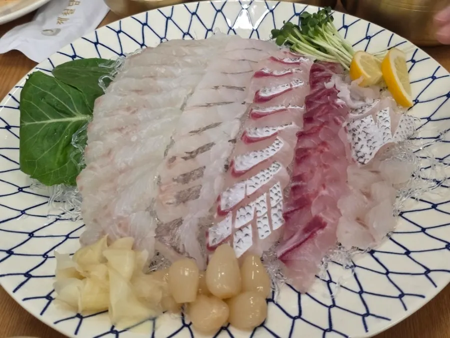 도톰하게 썬 모둠회가 겹겹이 깔린 큰 접시
