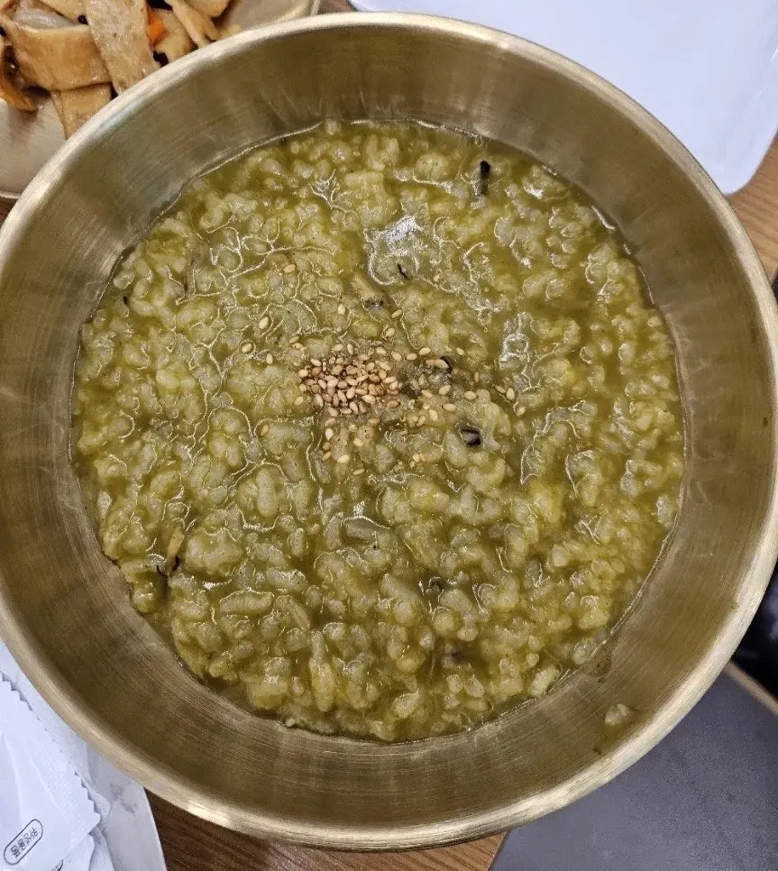 Abalone intestine porridge served in a brass bowl
