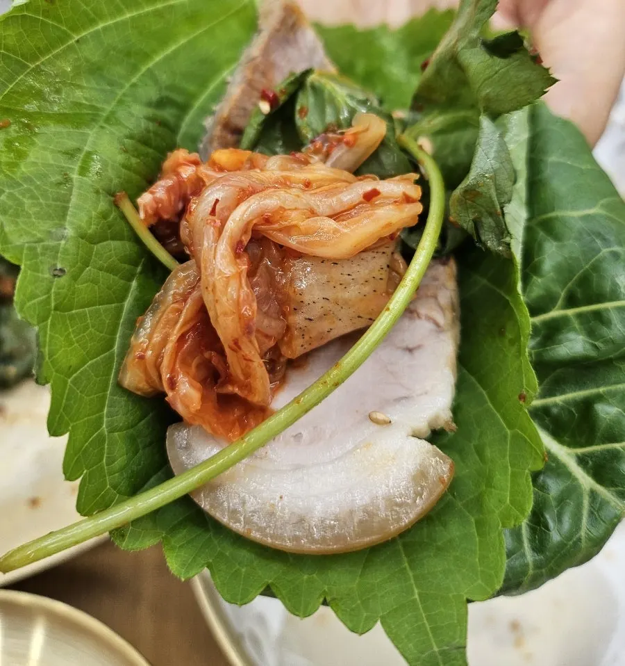A piece of cold pork with chamnamul greens