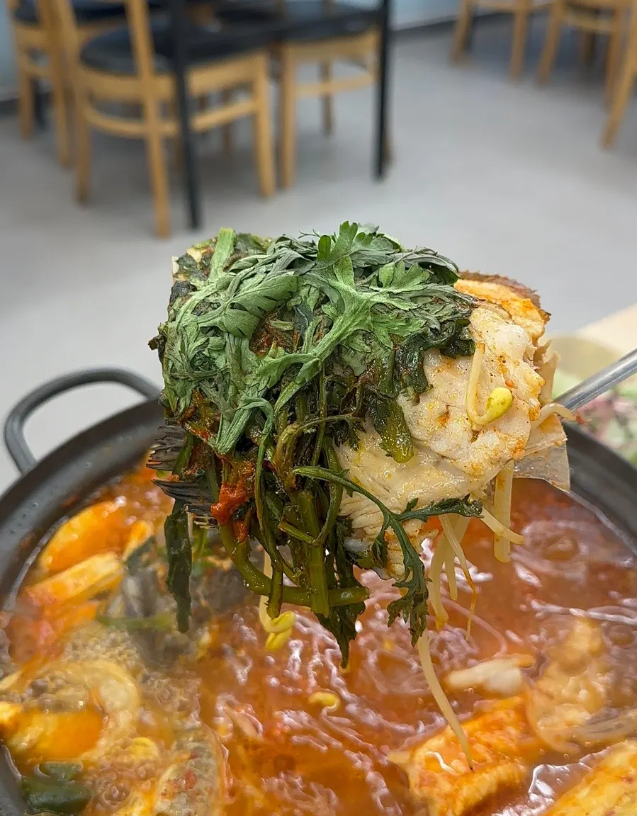 Fish stew simmering with pieces of fish flesh