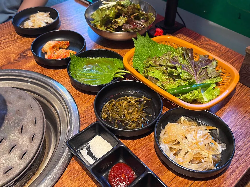 Side dishes set up alongside charcoal at Usijang Hoegwan
