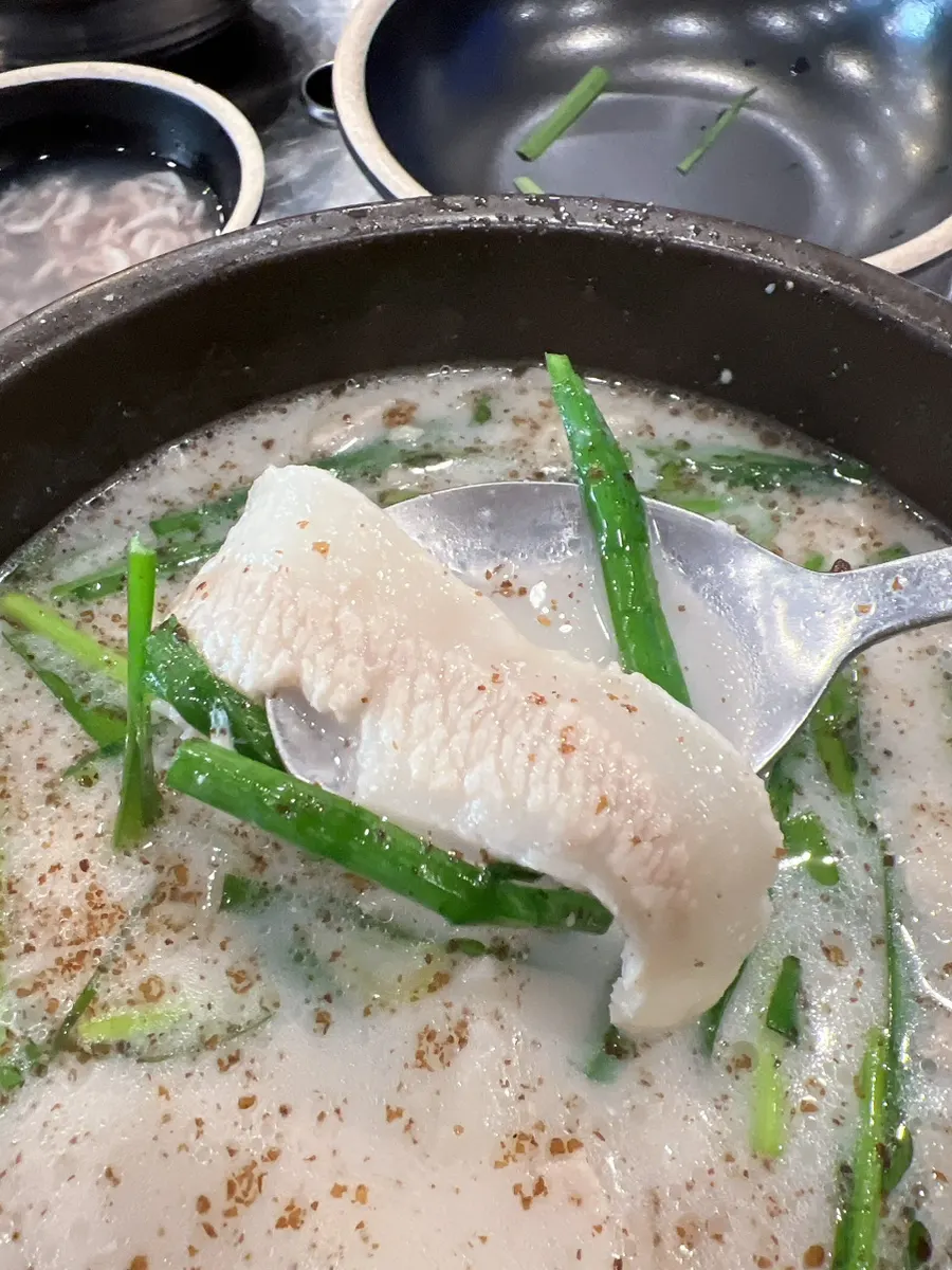 Taking a spoonful of the hangjeong-suyuk gukbap