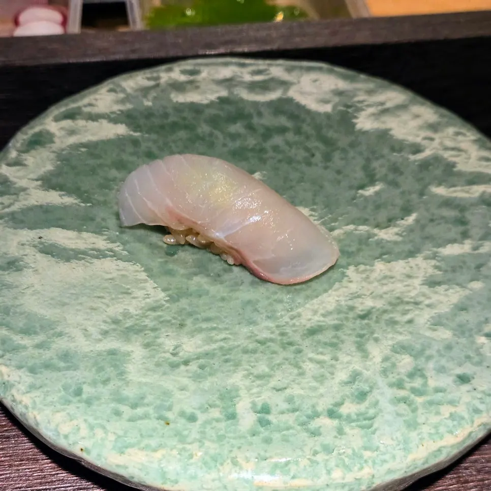 Sushi being prepared in sequence at the counter