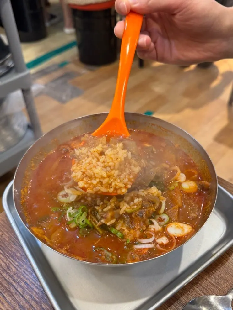 A bowl of spicy gukbap with a sharp, savory broth