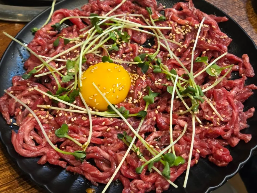 Plate of raw beef topped with egg yolk at Usijang Hoegwan