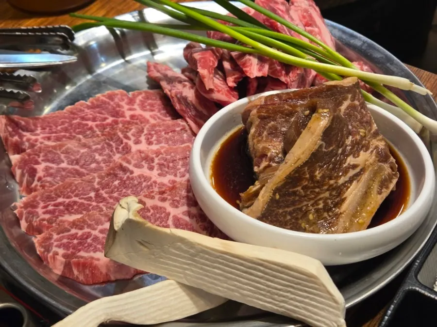 Tray of grilled beef, marinated ribs, and king oyster mushrooms