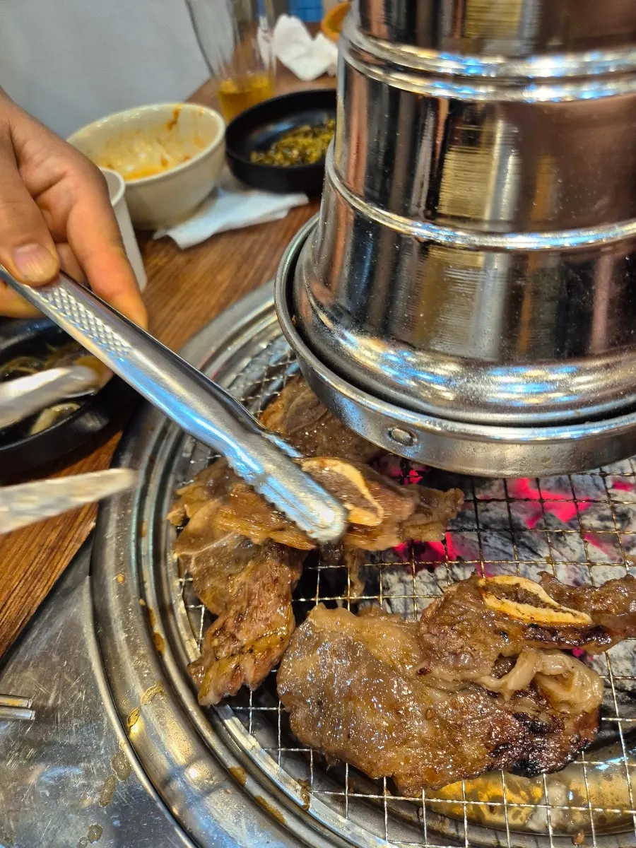 Thick short rib grilling over charcoal