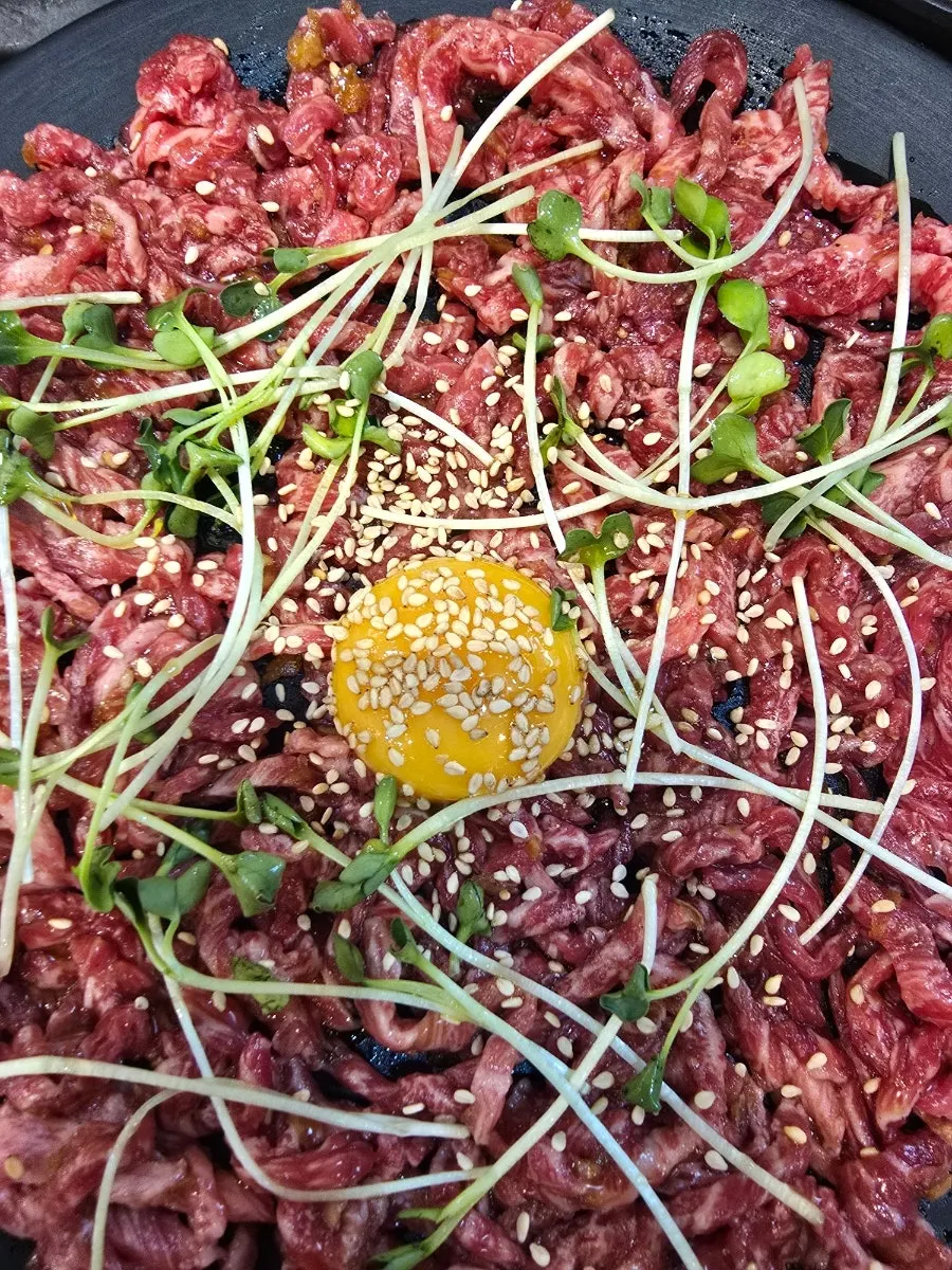 1++ hanwoo yukhoe topped with radish sprouts and egg yolk