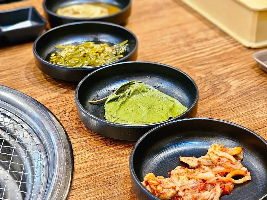 Side dish setting with dressed lettuce salad and kimchi