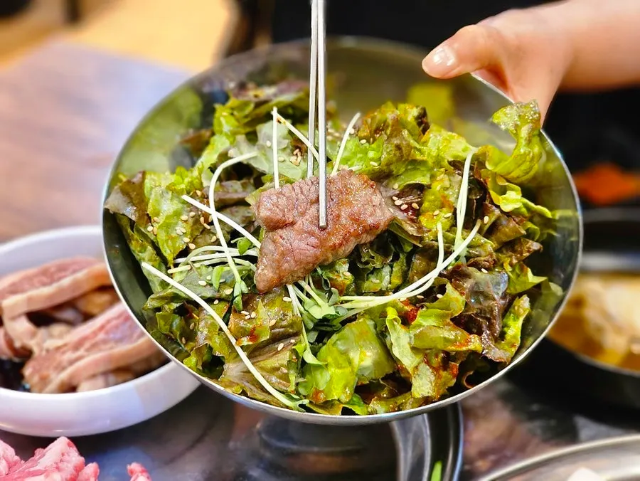 Refilled plate of dressed lettuce salad