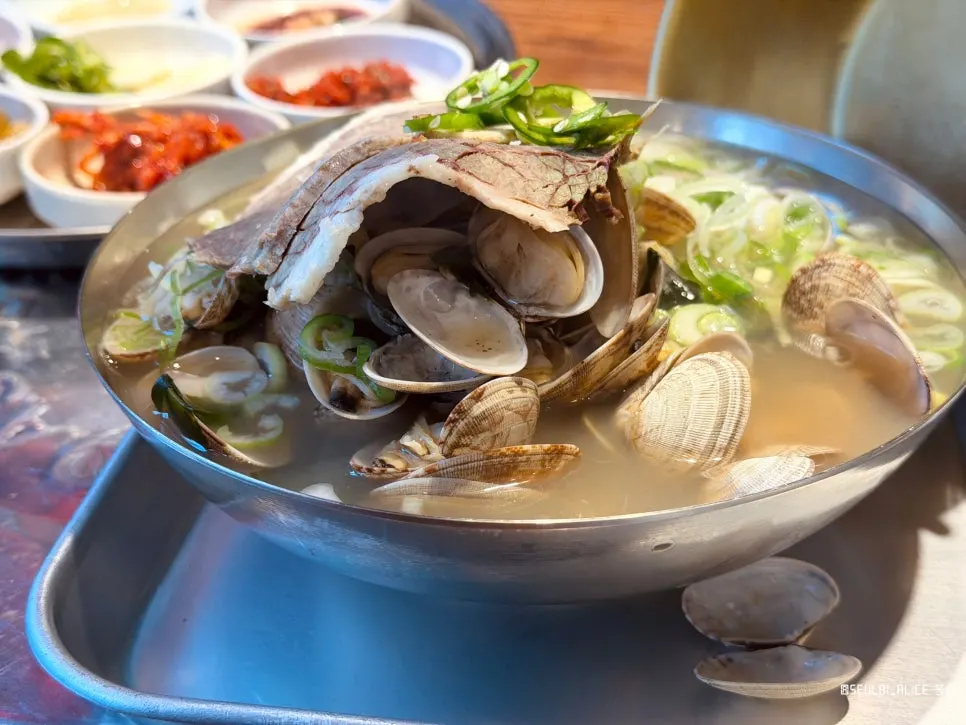Clams peeking out from beneath the beef in the soup