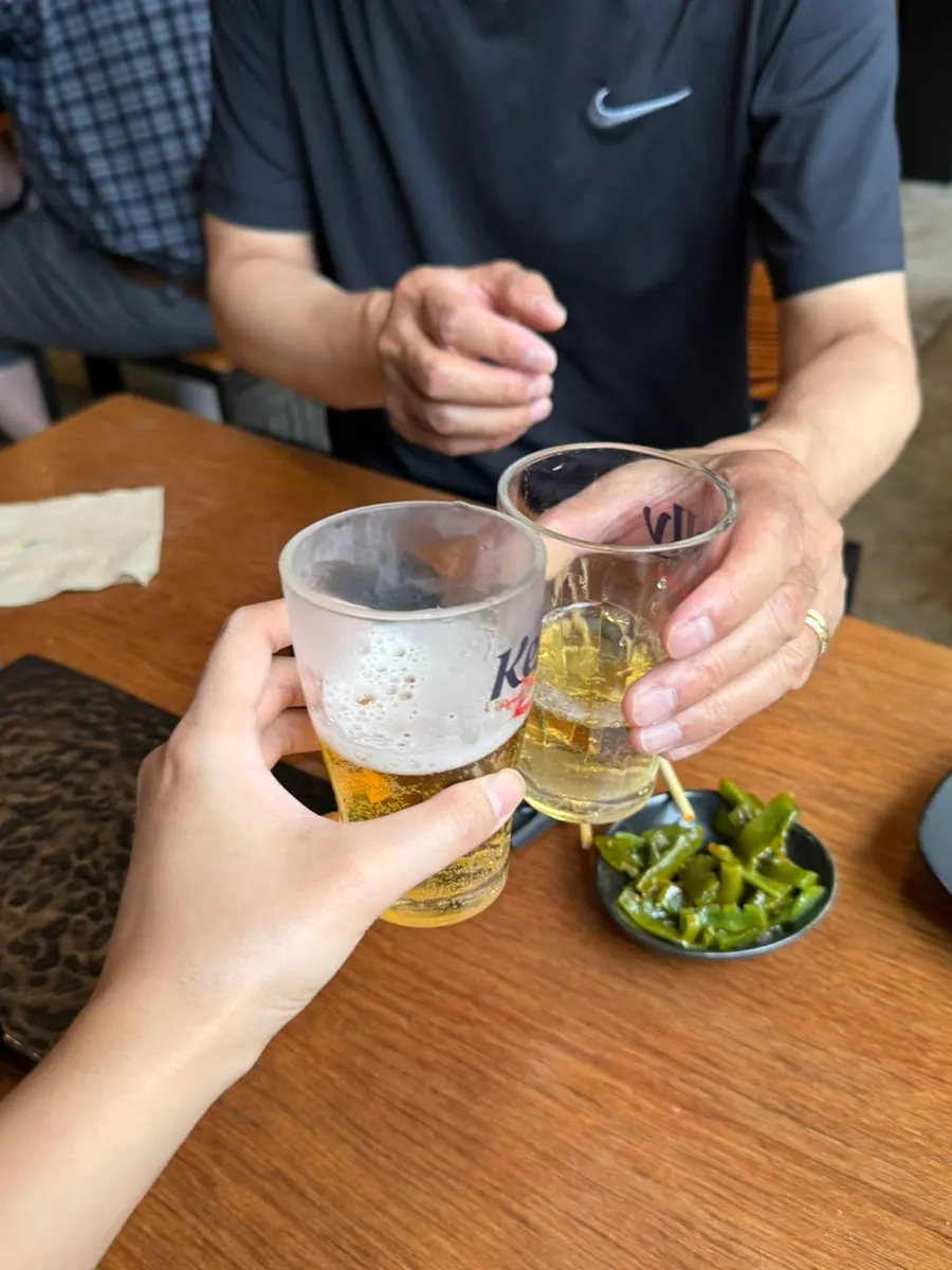 Glasses raised for a toast before the main skewers