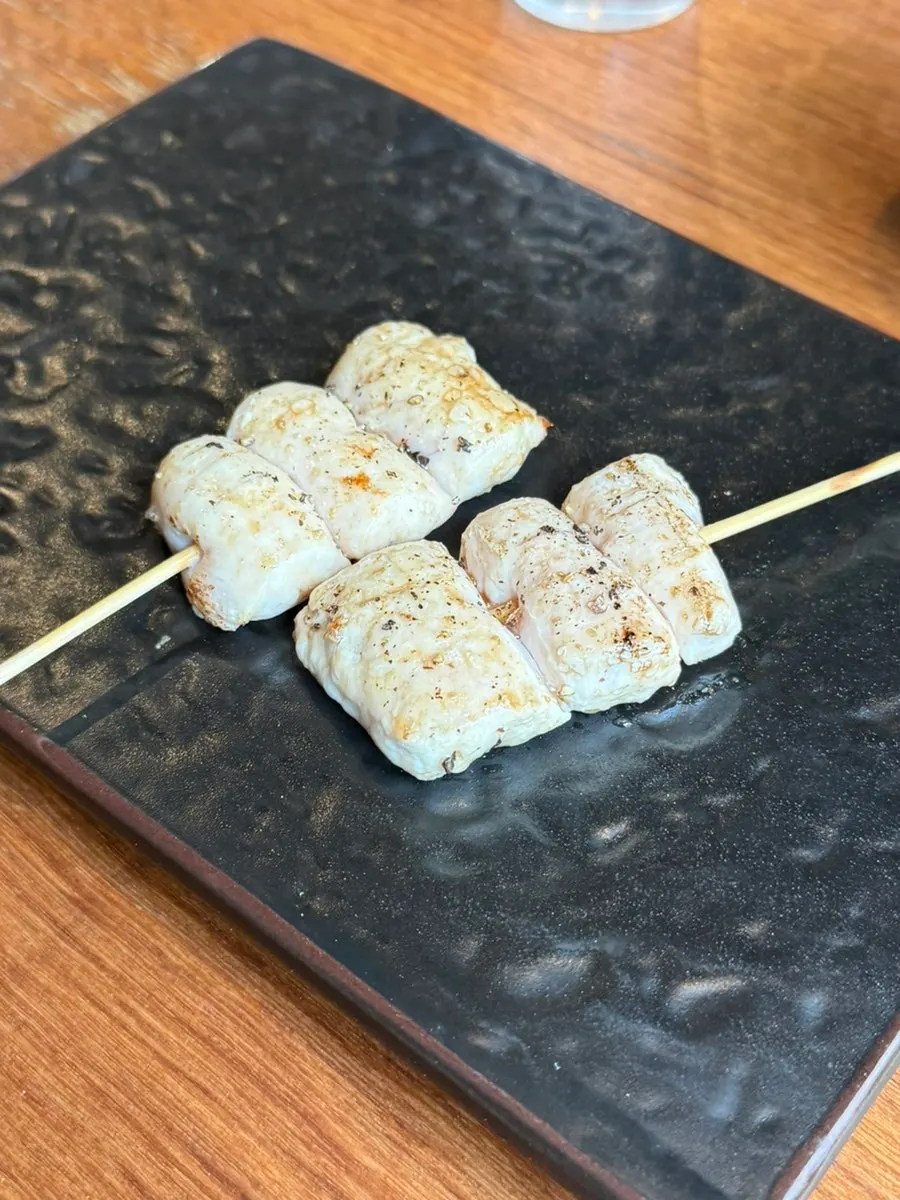 The first yakitori skewer with rising smoky char