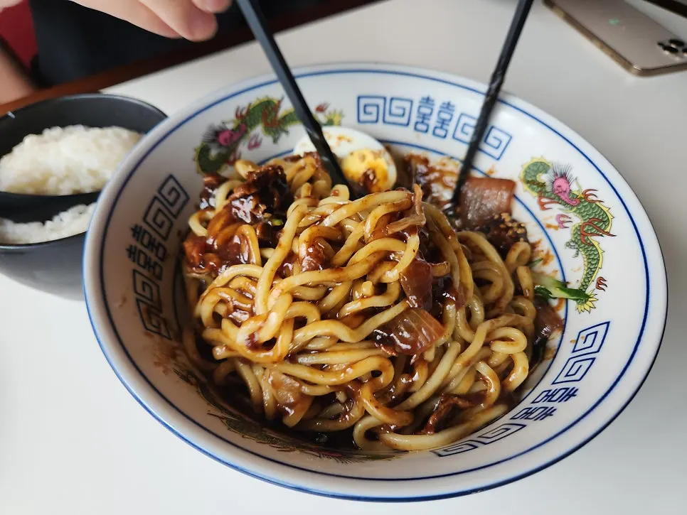Jjajangmyeon noodles lifted with chopsticks