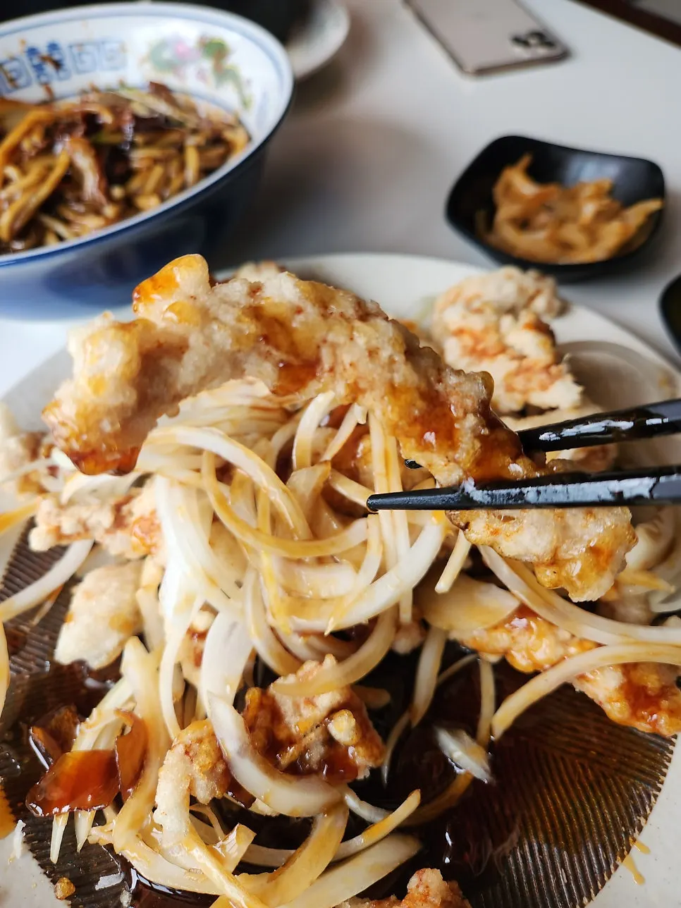 A piece of tangsuyuk picked up with chopsticks