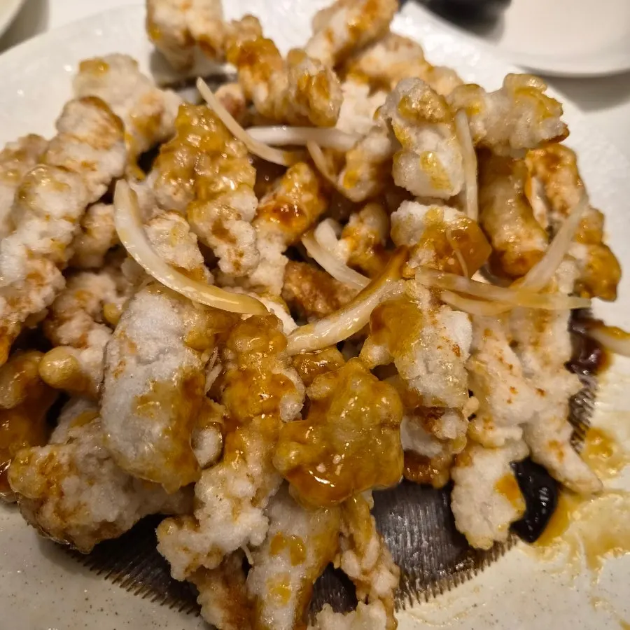 A piece of black vinegar tangsuyuk picked up with chopsticks