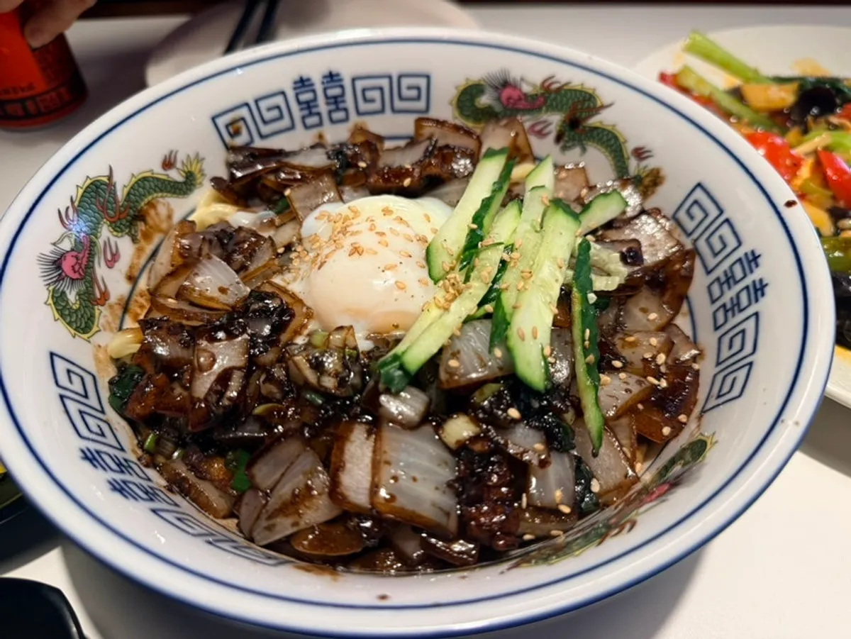 Jjajangmyeon pekat bertelur separuh masak dengan hiasan timun rangup