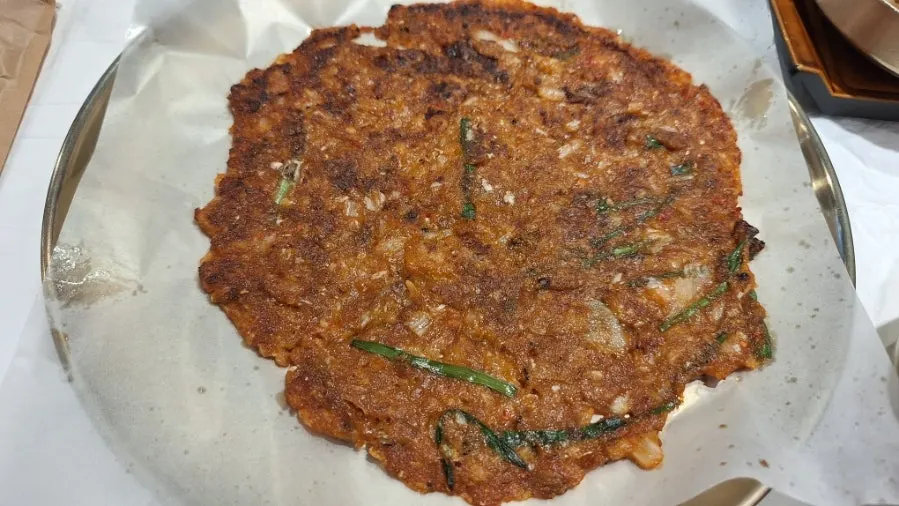 Table with kimchi pancake and parboiled squid salad