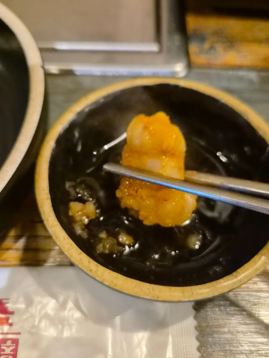 A piece of tripe dipped in sauce