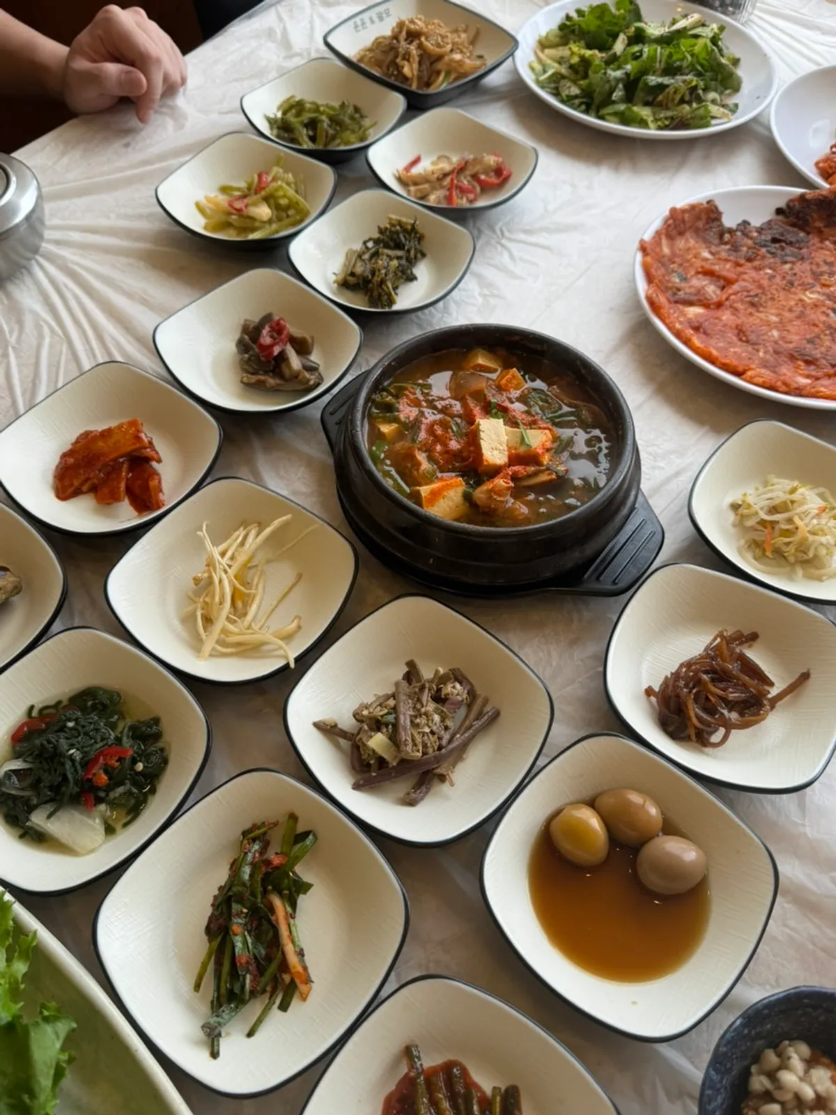 Side dish spread including tofu kimchi and quail eggs
