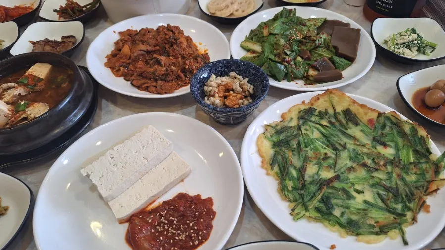 Main side dishes: spicy pork stir-fry, acorn jelly salad, tofu kimchi, and chive pancake