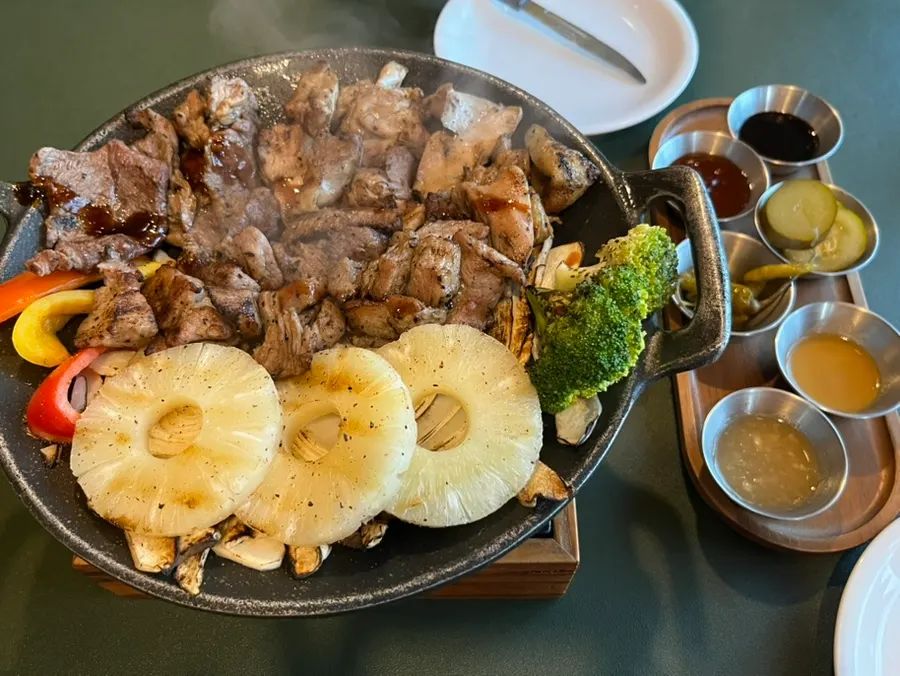 A piece of charcoal-grilled meat dipped in sauce