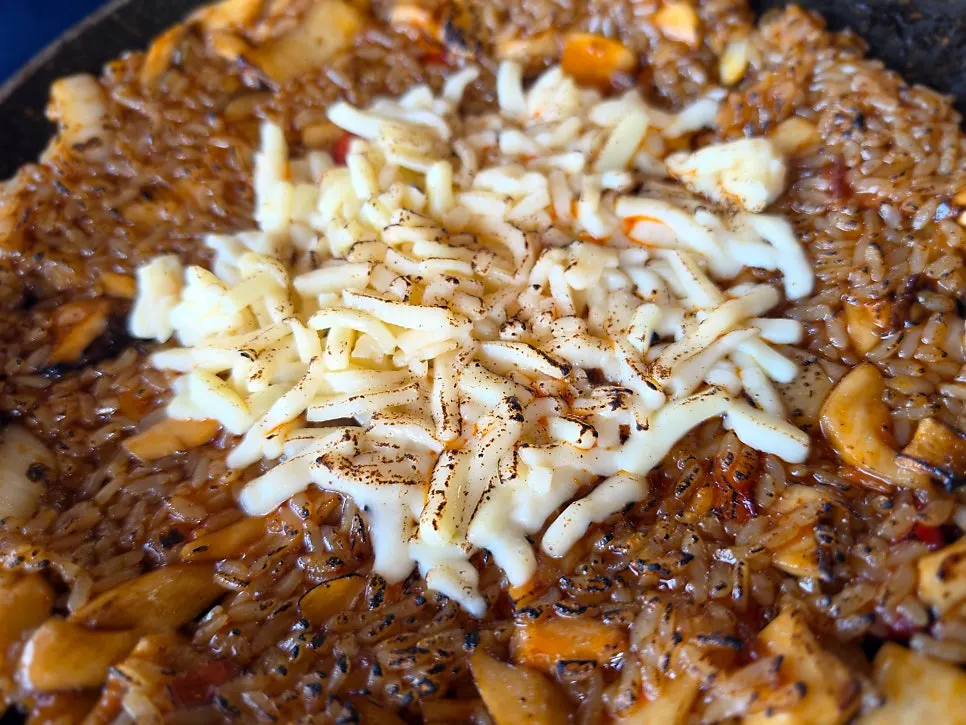 Fried rice topped with cheese and spicy sauce