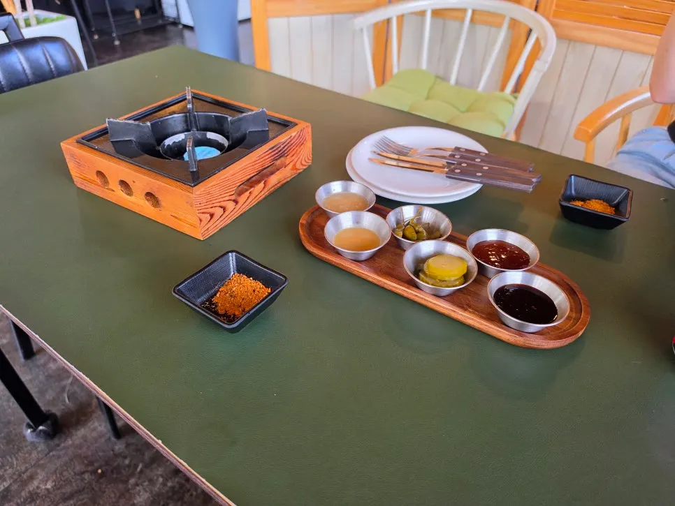 Mini fire pit with two sauces, pickles and olives as basic setting