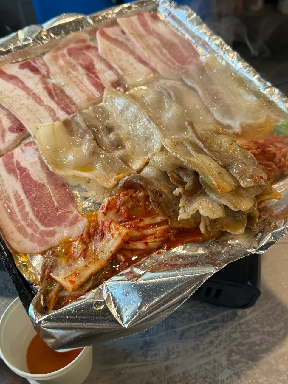 Flash-frozen pork belly grilling on the griddle