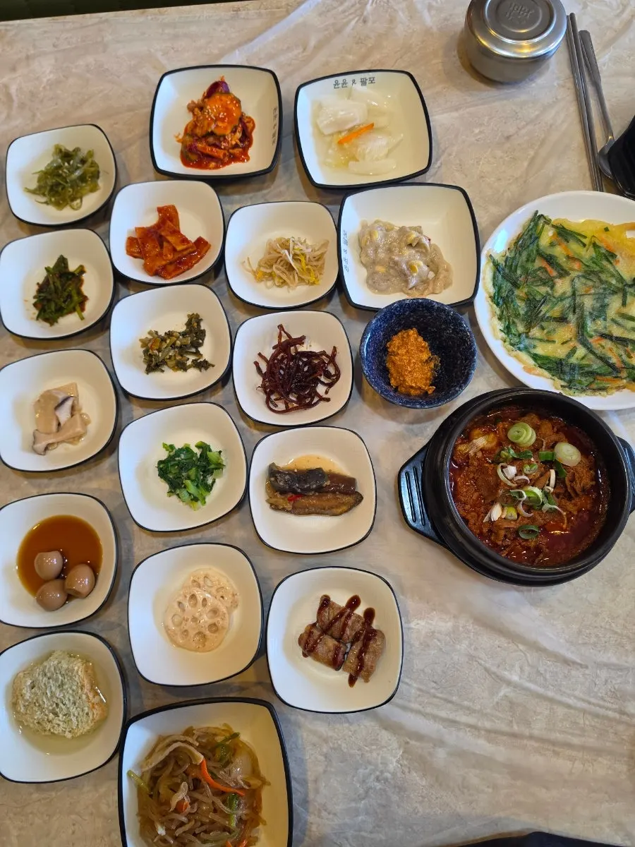 Table piled high with Korean set-meal side dishes