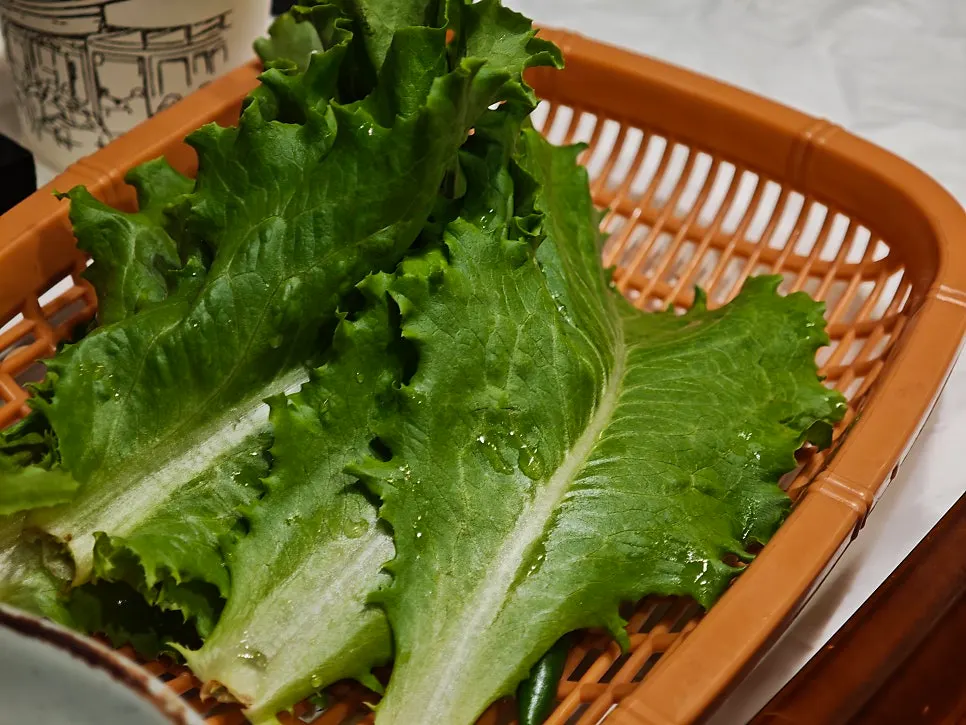 Grilled bulgogi placed on lettuce for a wrap