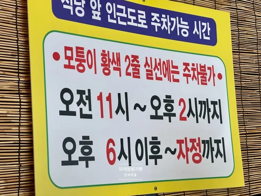 Sign showing permitted parking hours on the road in front of Yun Sikdang