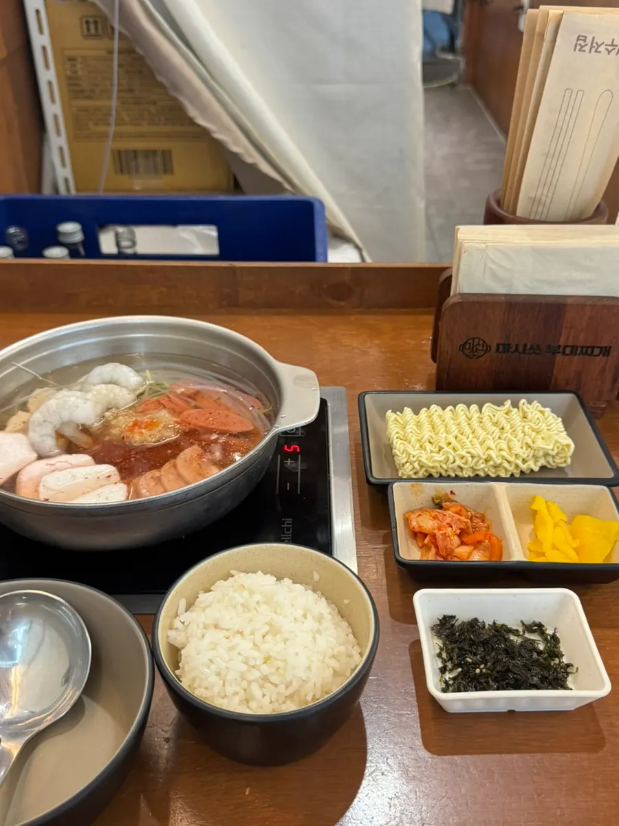 Đồ ăn kèm cơ bản gồm rong biển vụn, củ cải muối, kimchi và nửa gói mì sari