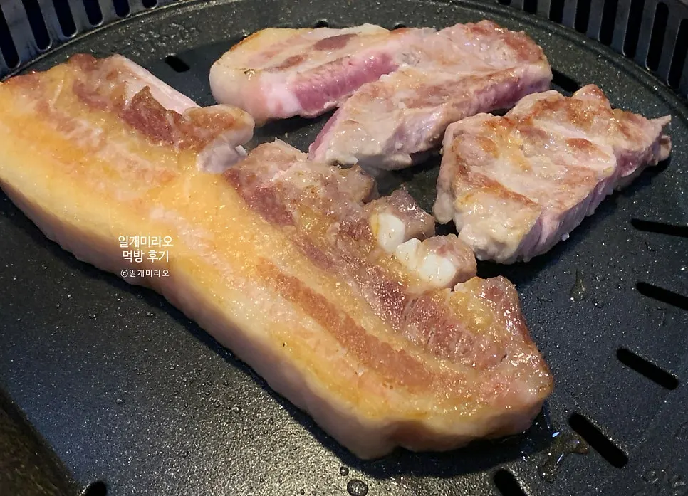 Staff grilling pork belly on the tabletop grill